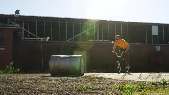 BMX rider doing trick in an empty yard