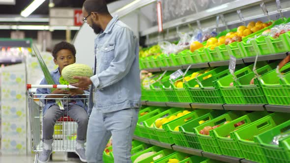 Man Pulling Trolley and Talking to Son