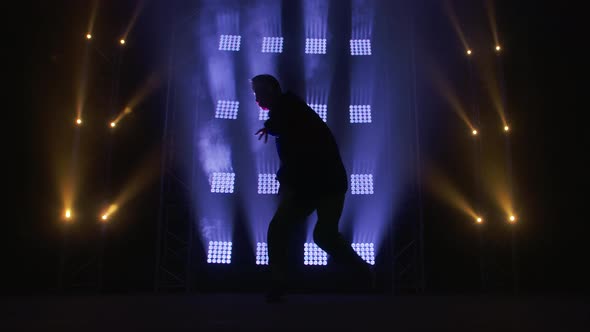 Silhouette of a Talented Young Hip Hop Dancer. Hip Hop Street Dance on a Stage in Dark Studio with