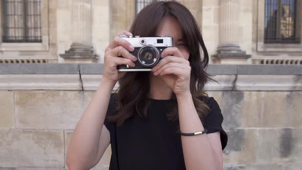 Cheerful Young Woman with Dark Hair in Black Tshirt Taking Photos