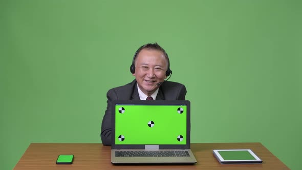 Mature Japanese Businessman Working As Call Center Representative