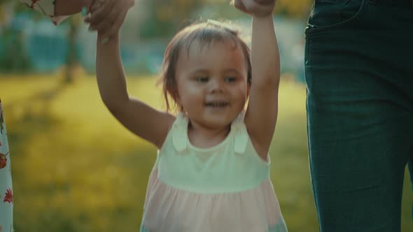 Little Girl Walking with Her Parents Holding Hands