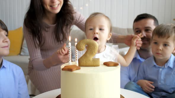 Cute Little Child Girl Is Blowing the Candles on Birthday Cake