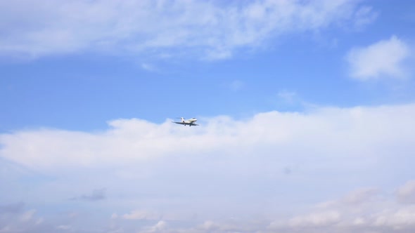 Landing airplane passing by at low altitude. Camera movements from left to right following the plane