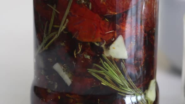 A Jar Of Sun Dried Tomatoes Doused With Olive Oil And Spices. Cooking At Home. Close Up Shot.