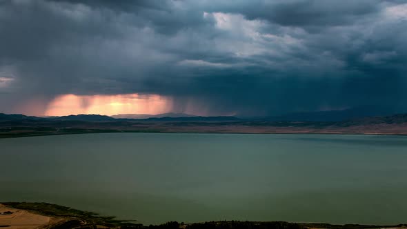 Dark storm clouds rolling over the landscape during colorful sunset