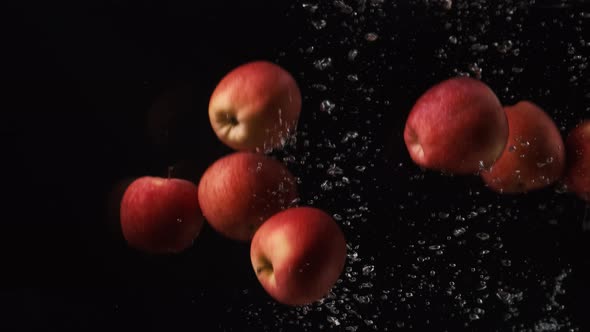 Red Apples with Water Droplets Collide on Black Background. Fruits Falling Into Water. Red Prince