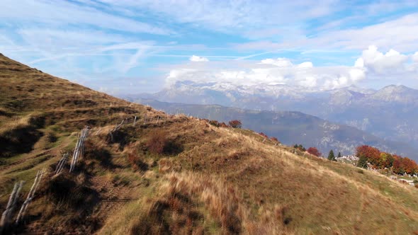 Flying low over pasture in Slovenia, with view towards Julian alps. Vibrant autumn colors.