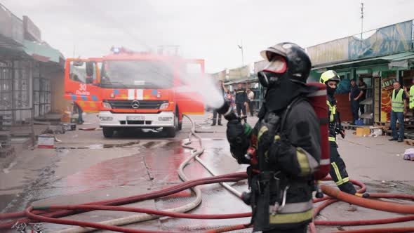 In the Background you Can See Fire Truck and Firefighters Fighting Fire and Water Pressure Coming