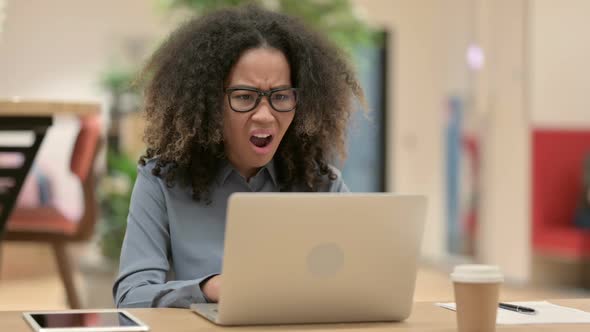 Young African Woman with Laptop Reacting to Loss