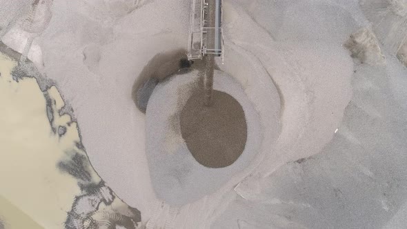 Aerial of a conveyor belt pouring sand on heap