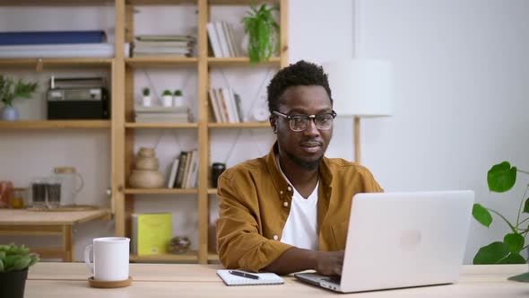 Smiling African Worker Working on Computer at Home Wearing Glasses Spbas