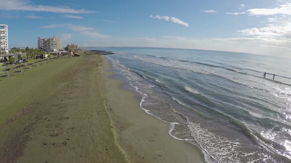 Sea waves washing ashore in Larnaca city, beautiful aerial view on beach