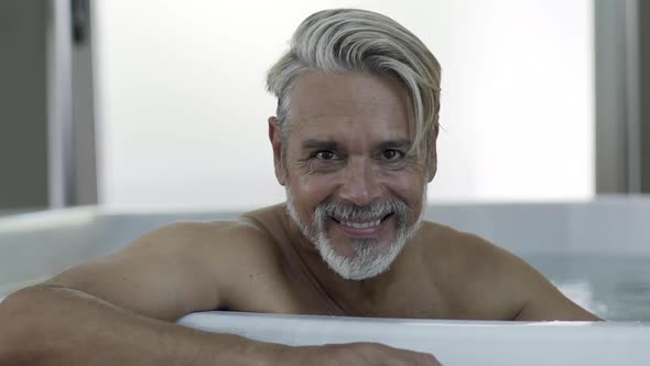 Portrait of man sitting in Jacuzzi