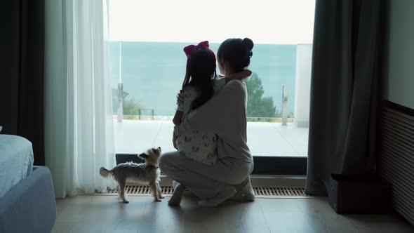 Asian daughter with mom hugging and looking at the view