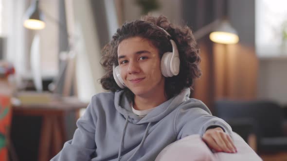 Portrait of Cheerful Teenager in Headphones at Home