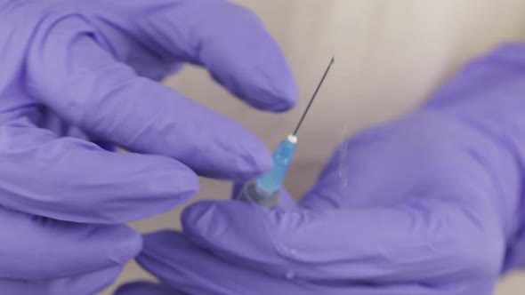 Doctor's Hands Release Excess Air From the Syringe, Preparing for the Injection