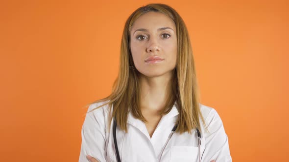 Portrait of Young Beautiful Female Doctor, Close Shot. Isolated on Orange Background, Studio Shot