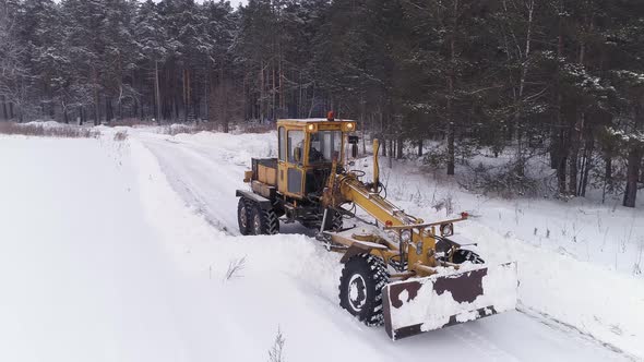 Aerial view of Snowblower Grader Clears Snow Covered Road next to the forest 13