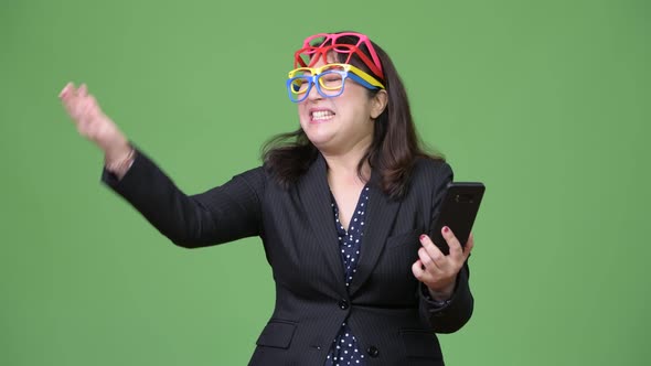 Mature Beautiful Asian Businesswoman Using Phone While Wearing Many Eyeglasses As Funny Concept