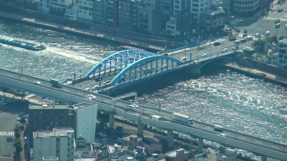 Aerial view of Tokyo river and ferry crossing under the bridge from Skytree tower.