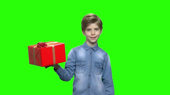 Boy in Denim Jacket Holding Red Gift Box and Pointing Finger