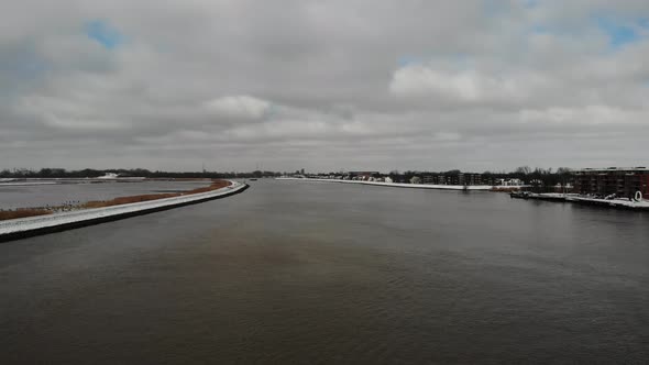 Cloudscape Over Serene Canal With Cargo Ship Laden Intermodal Containers Crossing On Noord River In