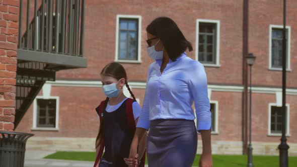 Schoolgirl Wearing Protective Face Mask Going to School with Mother During Coronavirus Pandemic