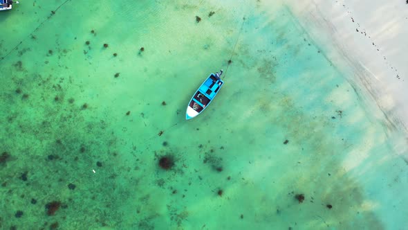 Aerial. Fishing boats floating on perfectly calm crystal clear seawater with corals on the sandy sea