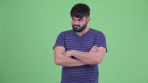 Angry Young Overweight Bearded Indian Man with Arms Crossed