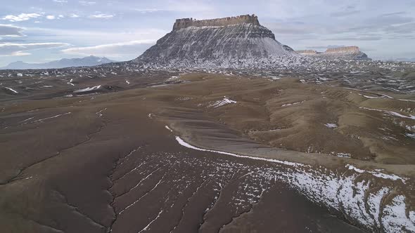 Flying over the rolling desert as snow melts eroding the landscape