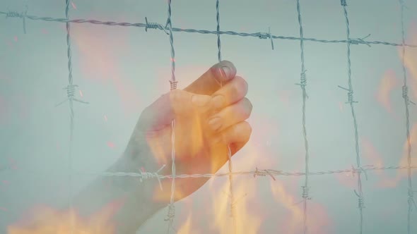 Hand Grasps At Fence In Fire And Smoke