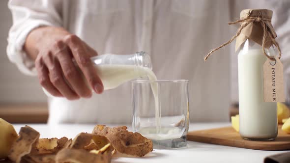 Potato Milk A Young Woman Chef Pours Vegetable Milk From A Glass Bottle With Her Hands. Vegetable