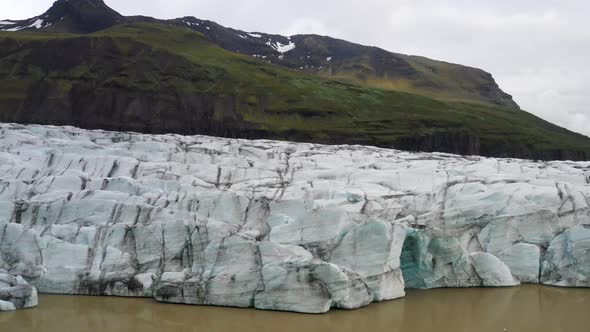 Glacier in Iceland with mountains with drone video moving close up.