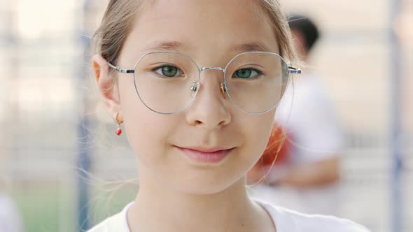 Portrait of Little Multicultural Schoolgirl in Glasses on Basketball Court