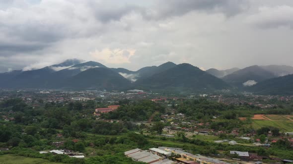 Panning shot drone capturing beautiful mellow little town of Ipoh, natural landscape with mountains