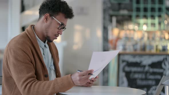 African Man Writing Paper Cafe