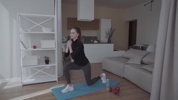 Sporty Young Woman Doing Squat Morning Exercise Alone in Living Room, Serious Fit Girl Wearing