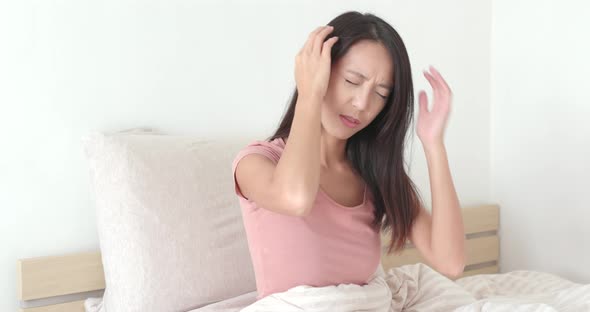 Woman suffer from headache on bed 
