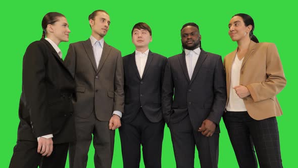 Group of Colleagues in Front of Camera Look at Each Other and Smile on a Green Screen Chroma Key