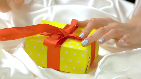 Manicured Hands Untied Ribbon on Gift Box.