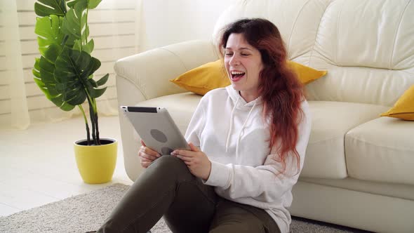 Self Isolation Concept. Young Woman Sitting on a Sofa in the Living Room and Talking Via Video Call.