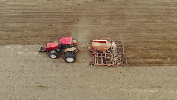 Farmer on a Modern Tractor Performs Processing of Dusty Soil with a Multifunctional Sowing Unit