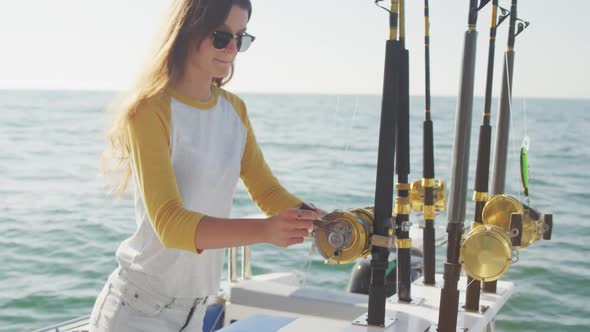 Side view of a teenage Caucasian girl holding a fishing rod on boat