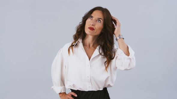 Female in White Shirt and Black Skirt is Thinking About Something Scratching Her Head Shrugging