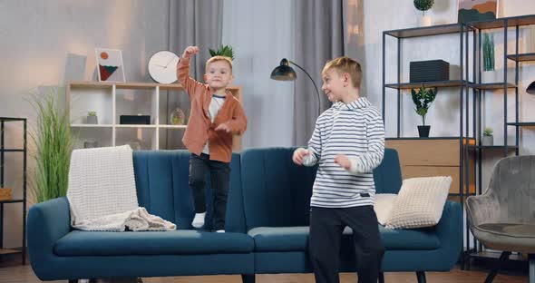 Two Boys-Small and Teen Having Fun Together at Home with Funny Dances