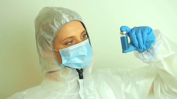 Virologist Woman in Chemical Protection Mask Glasses and Gloves Holding Potential Vaccine at the Lab