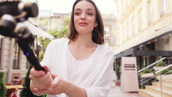 Vlogging. Woman filming video on camera at city street