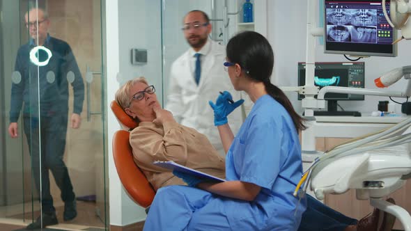 Dentist Assistant Interrogating Senior Woman