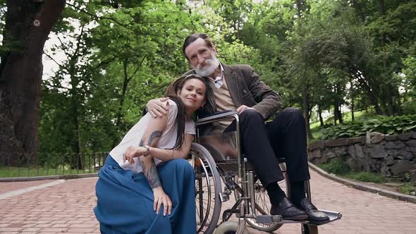 Trendy Woman and Her Sedentary Contented Respected Bearded Old Granddad in Wheelchair